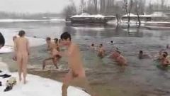 Uomini magri che immergono nel lago d'inverno