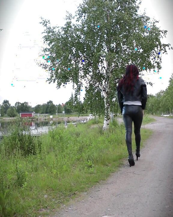 Elle marche dans une tenue en cuir et des talons.