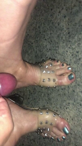 Desnuda en la calle con chupones de leche en sandalias transparentes