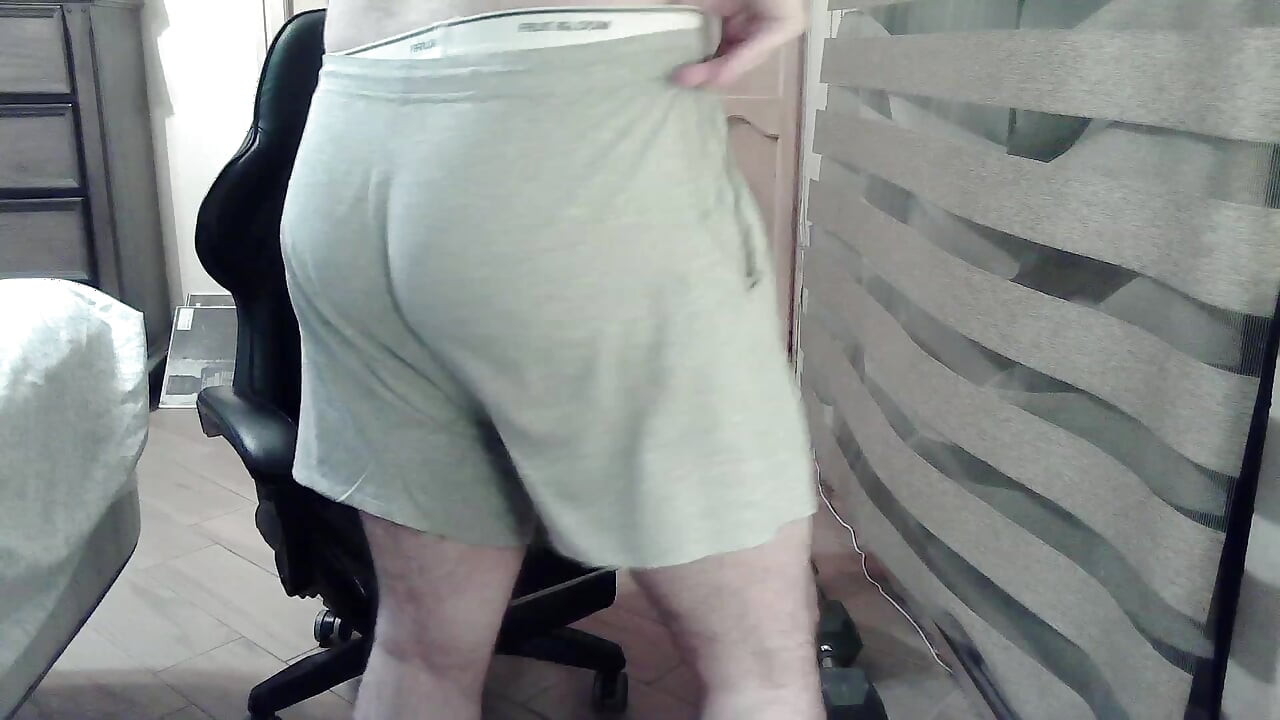Muscular camboy flexes his muscles and squats