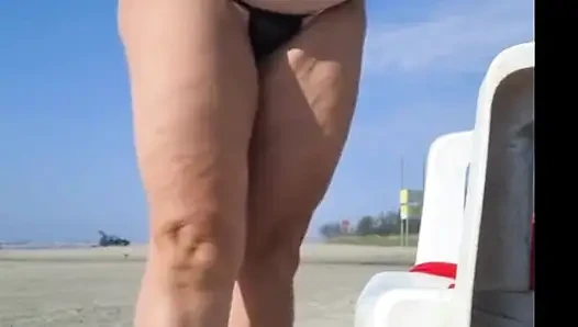 Hot crown sunbathing on the beach in transparent micro bikini