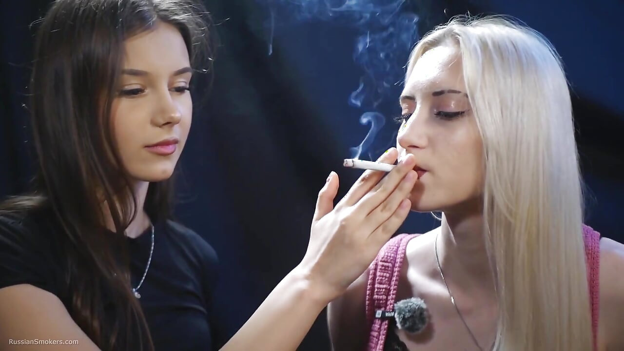 Dos chicas compartiendo un cigarrillo en una lenta sesión de fumar íntima