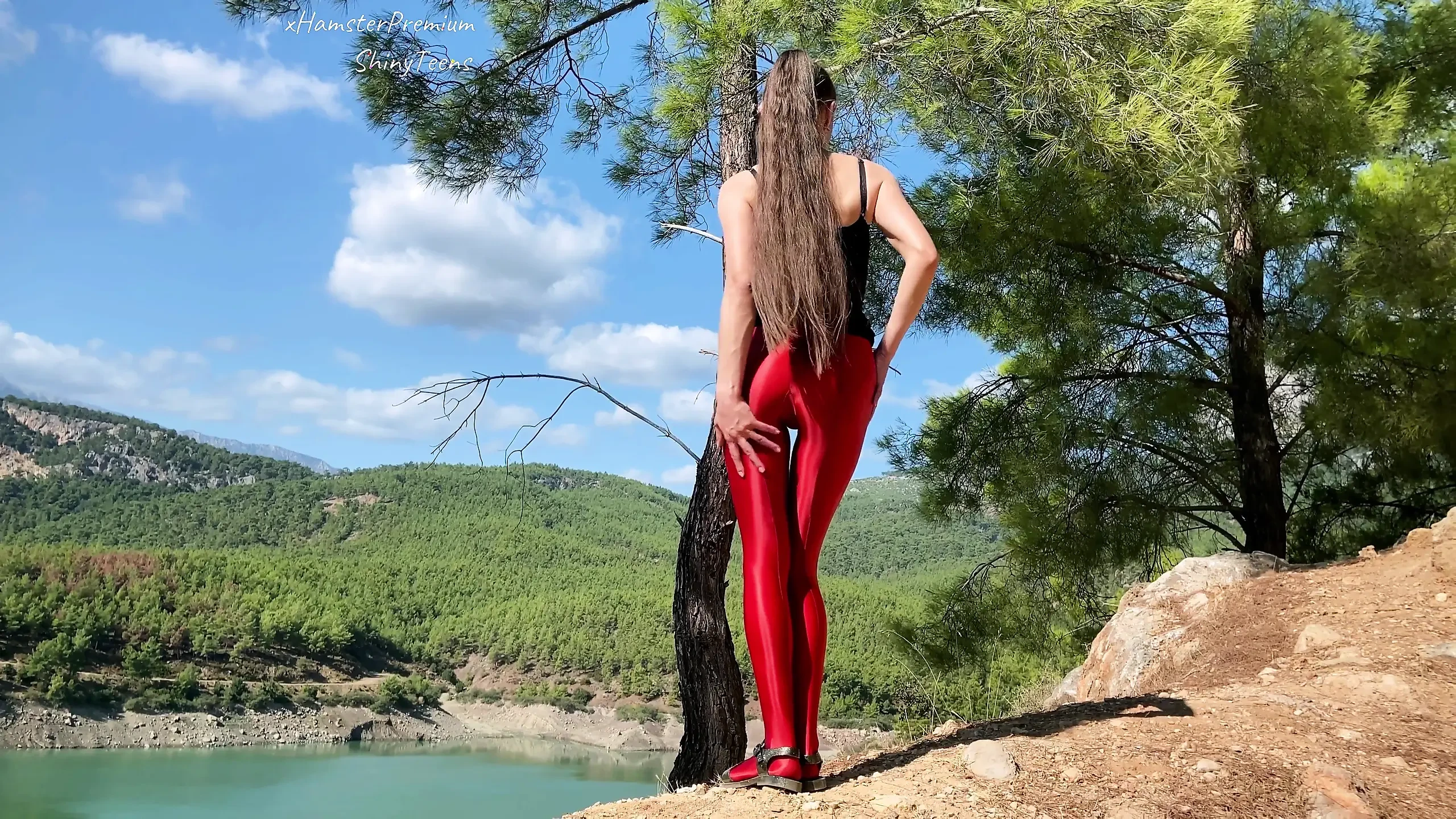 Shiny lycra red pantyhose and black microdress on the mountain