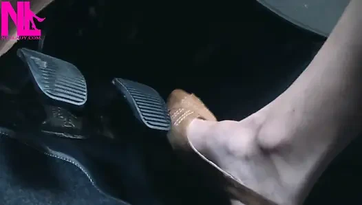 Açık kahverengi gözetleme toynağı sandaletle canlanıp araba sürüyor