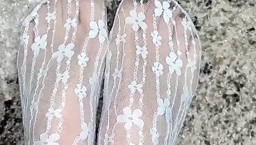 Massaging feet in sexy socks with hands in gloves