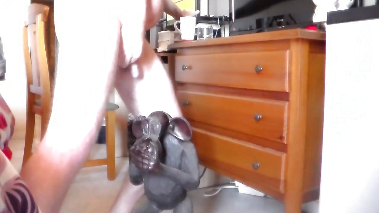 John fait pipi sur une statue de singe