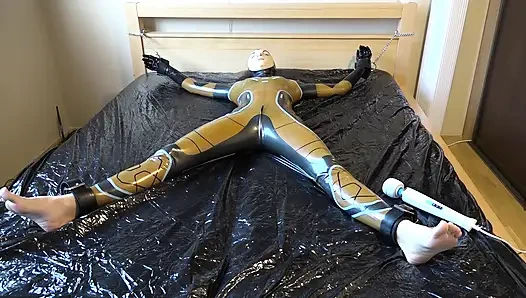 Latex Danielle is attached to the bed and masturbated with the massage vibrator