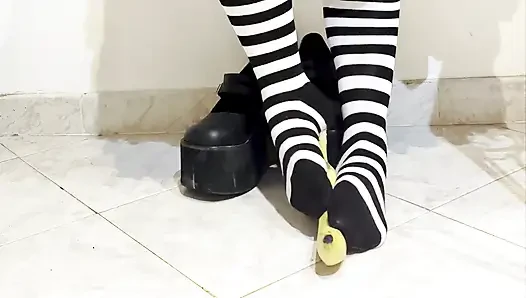 Goth crushing a banana under her shoes