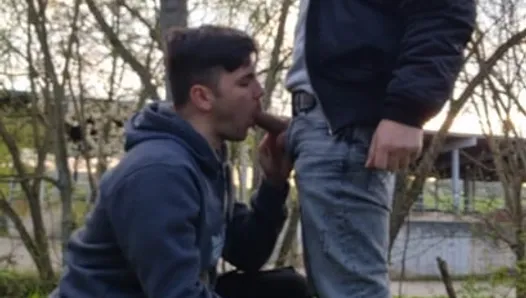 Deux garçons sexy à grosses bites fument, se branlent et sucent dehors