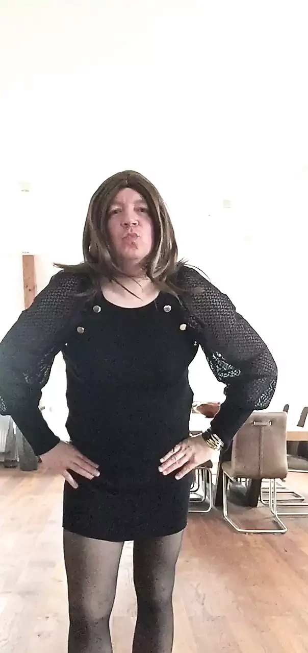 Nicki-Crossdress w czarnej mini sukience, czarnych rajstopach i trampkach