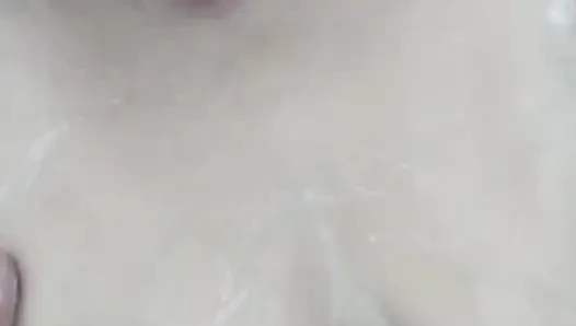 Ateşli olgun kadın banyoda rahatlıyor ve duşun altında köpükle mastürbasyon yapıyor