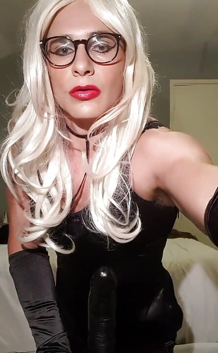 Trening dubokog grla u uskoj crnoj haljini satenskoj haljini, čarapama, satenskim operskim rukavicama, plavuša, karmin, naočare, frustrirana u čedu