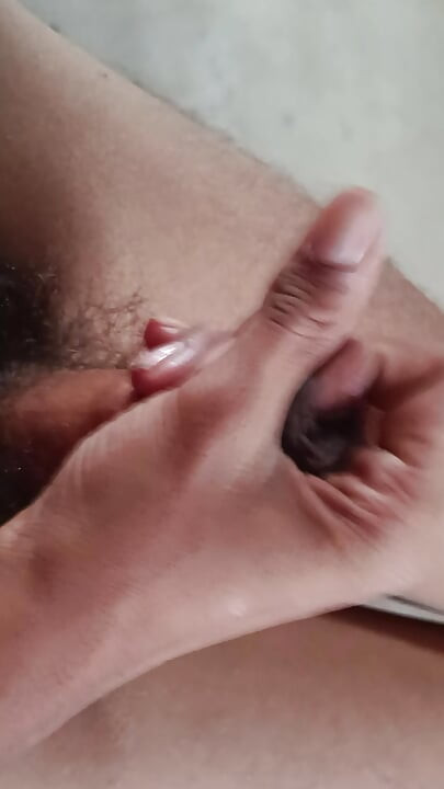The boy is shaking his penis in his hand and ejaculating.