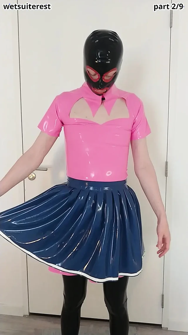 Putting on blue latex skirt over pink rubber maid dress and stockings, layers