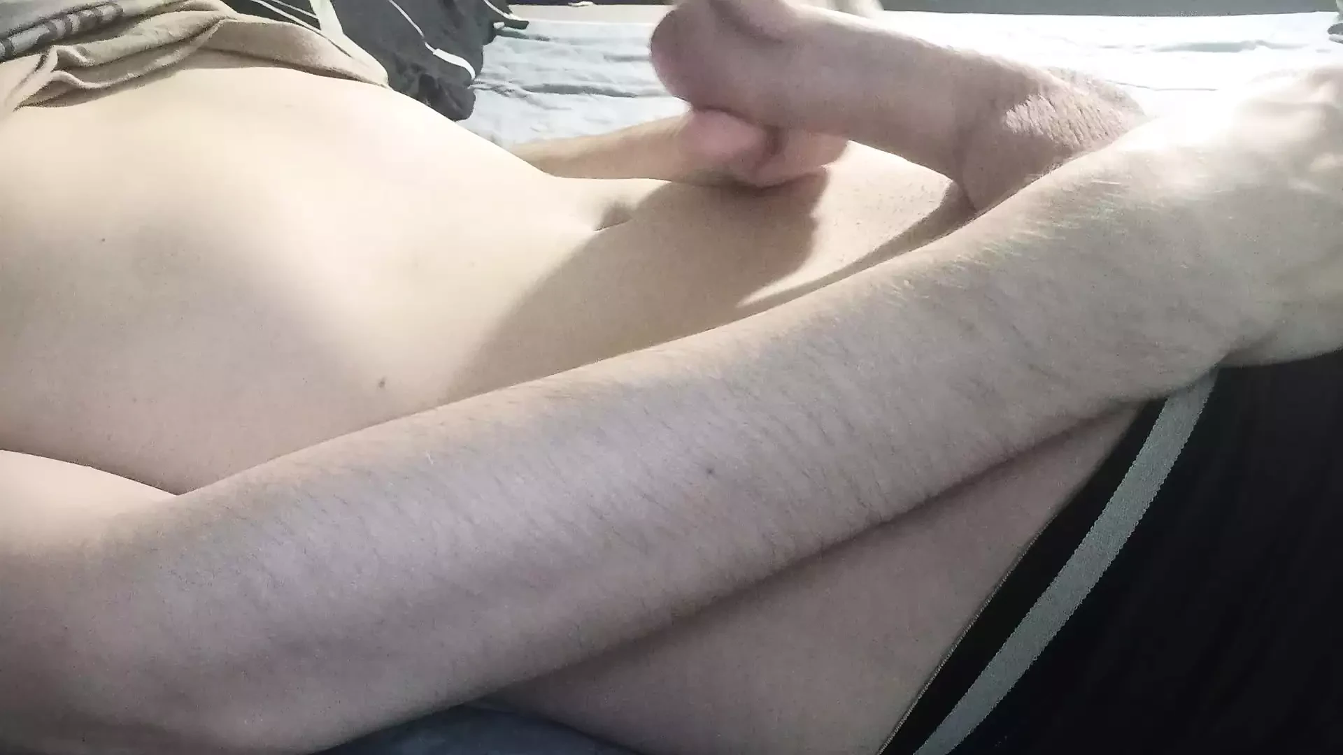 The guy jerks his dick lying on the bed