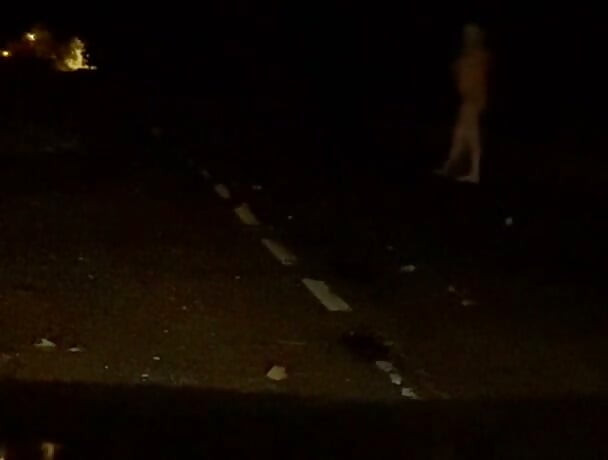 Naked in road and hiding the wrong side of road from safety when car passed