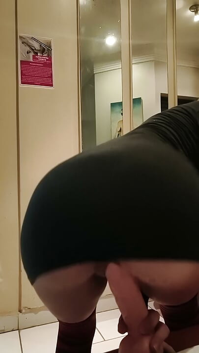 Kvinde i kjole skubber dildo ind i sin fisse