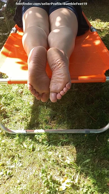 I'm laying on my belly outside in the sun. I wriggle my toes and I show my soles.