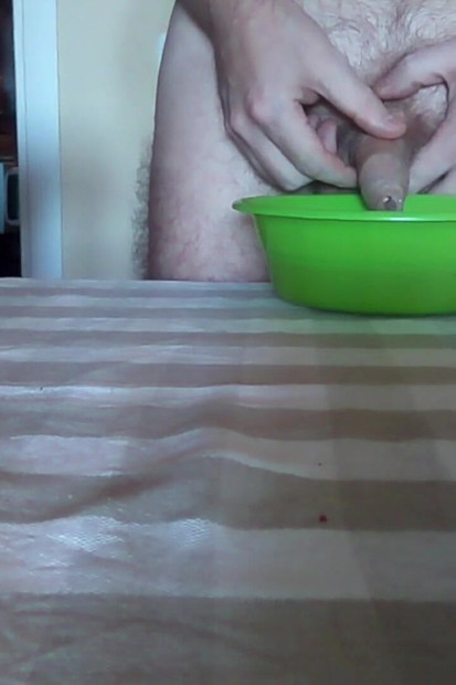 ジョンはテーブルの上の緑色のボウルにおしっこをしています