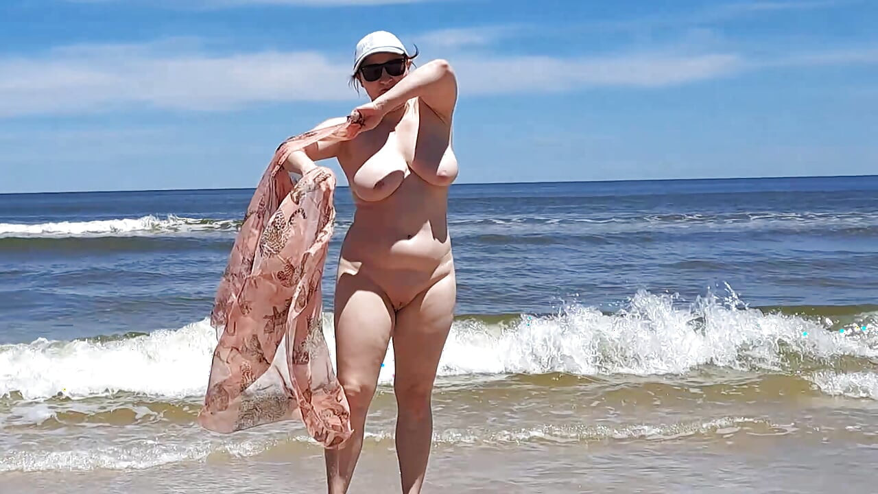 Amateurfilmen. Ein fkk spielt mit Wellen am meer.