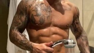 Garanhão muscular tatuado lavando seu pau enorme