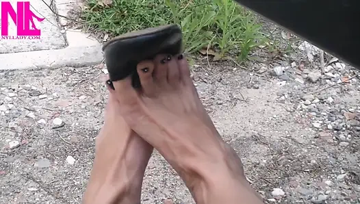 Schuhspiel mit schwarzen Lederflats barfuß draußen