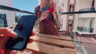 Heißes Mädchen masturbiert Bluetooth-Vibrator ein Restaurant im Freien
