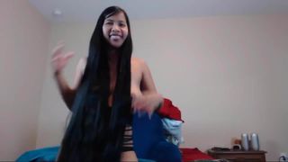 Schattige langharige Aziatische striptease en haarspel