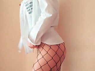 Striptease van een meisje in een shirt en een visnetpanty
