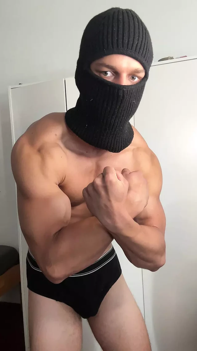 Masked young hunk showing off his muscles