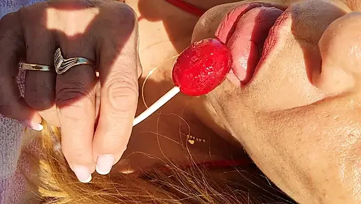 Melissa johnson lutscht und leckt einen kirschenlutscher am .beach