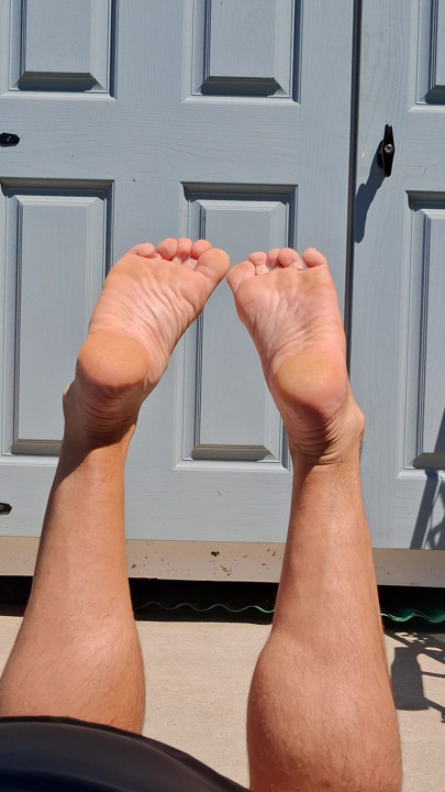 My girlfriend shoots my bare feet while I tan