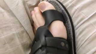 Dedos em sandálias que têm laçada ao redor do dedão do pé
