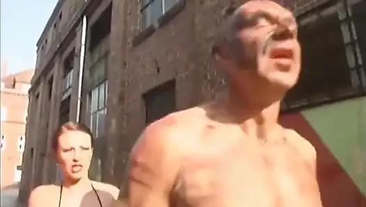 Gimp gets his big dick rubbed outdoor by the mistress