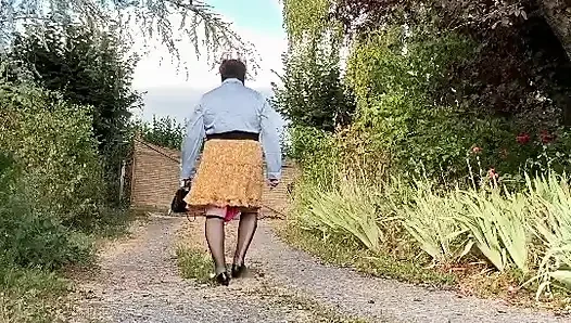 Bir akşam dışarıda çiçeklerle kısa sarı etekle gündelik giyiniyor