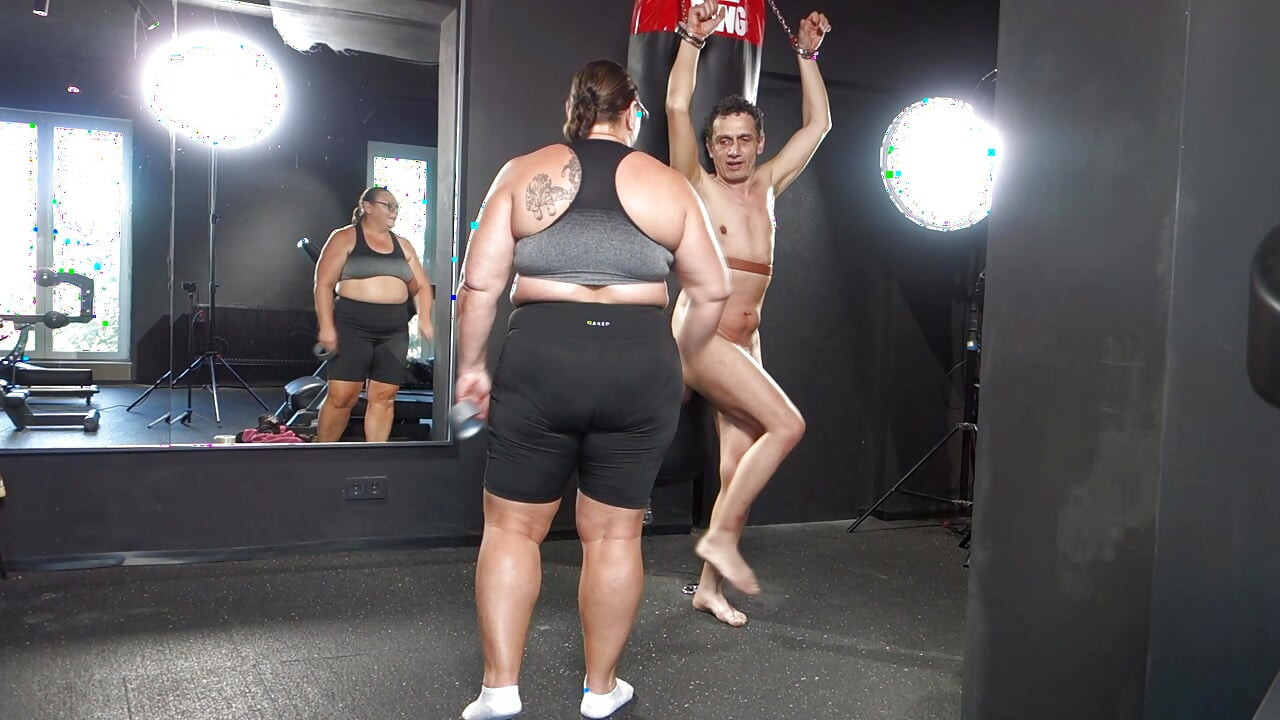 Mistress April practices boxing on a human punching bag.