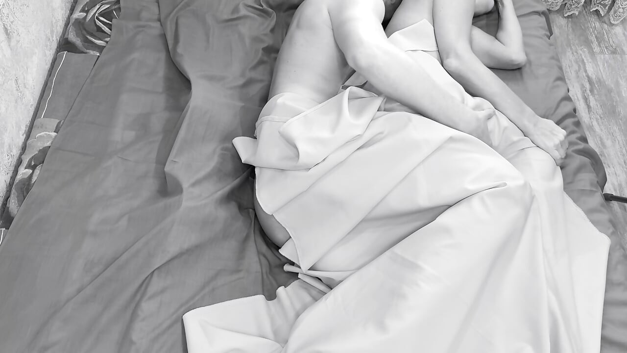 Couple caught on camera having sex in bed .