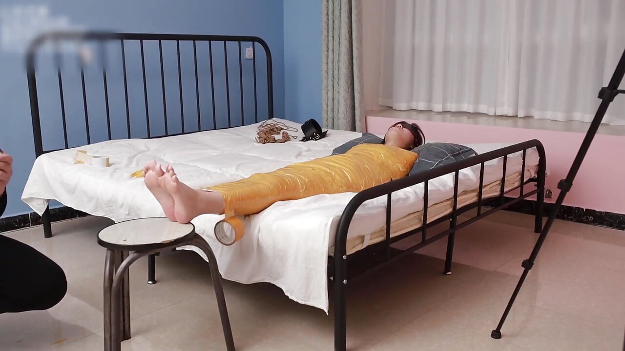 A Cute Barefoot Girlfriend Uses Tape to Bind Her Whole Body, Playing with Her Cute Bare Feet