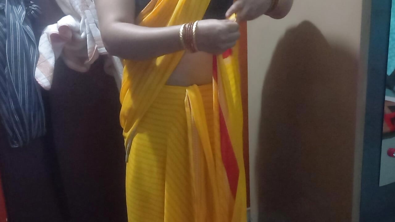 Indische hausfrau trägt einen gelben sari.