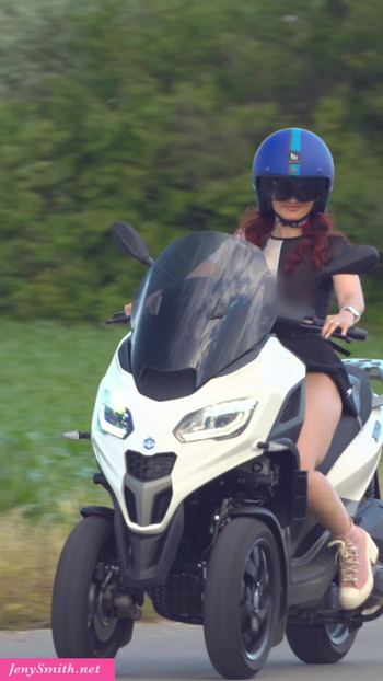 Jeny Smith kısa etekli bir motosiklete biniyor.