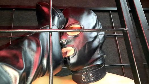 Caged slave licks dominatrix’ boots