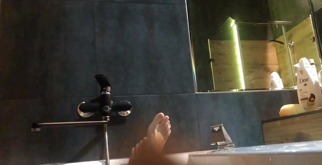 Aziatische voeten en poesje in een badkamer