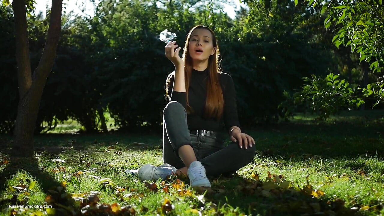 Seductora belleza rusa fumando cigarrillos al aire libre