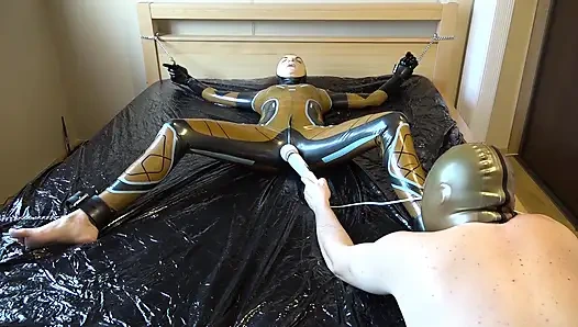 Latex Danielle wird am Bett befestigt und mit der massage mit dem vibrator masturbiert