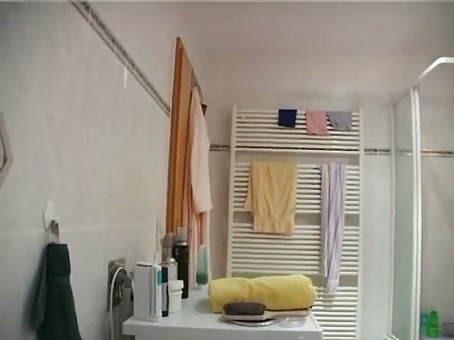 Small titted brunette is rubbing her hairy pussy in the bathroom