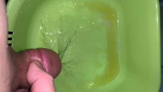Mały penis masturbuje się, cumming i pissing side on green miska