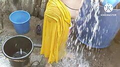 Indická žena v domácnosti se koupe venku