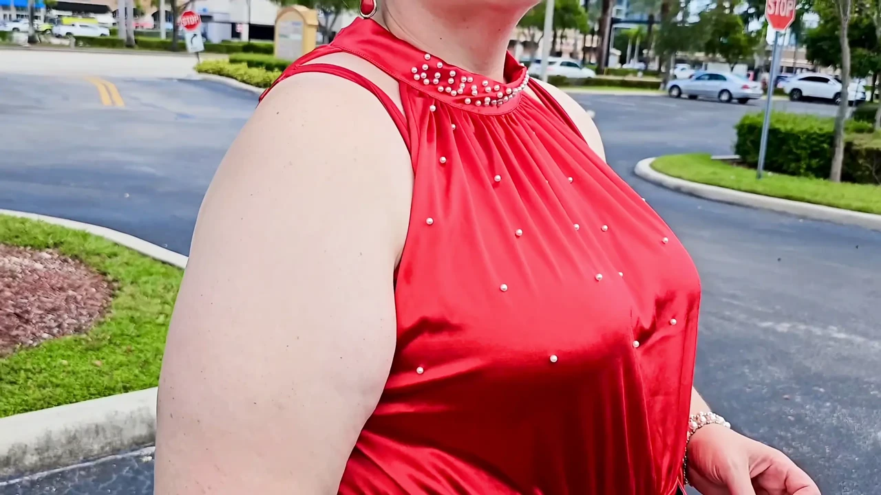 Beautiful woman walking outdoors in public parking lot showing off for strangers