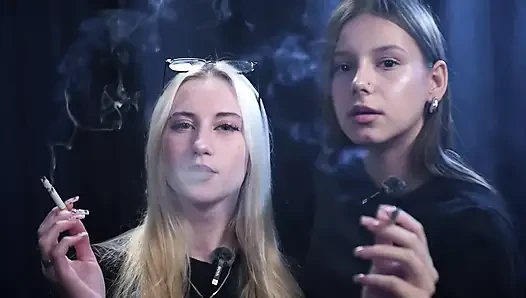 Zwei Frauen rauchen zusammen in einem dunklen Studio mit weicher blauer Beleuchtung