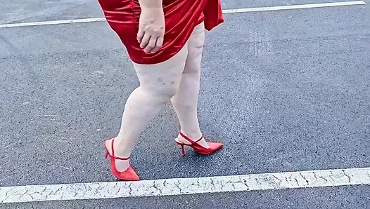 Wanita cantik berjalan di luar ruangan di tempat parkir memamerkan diri untuk orang asing